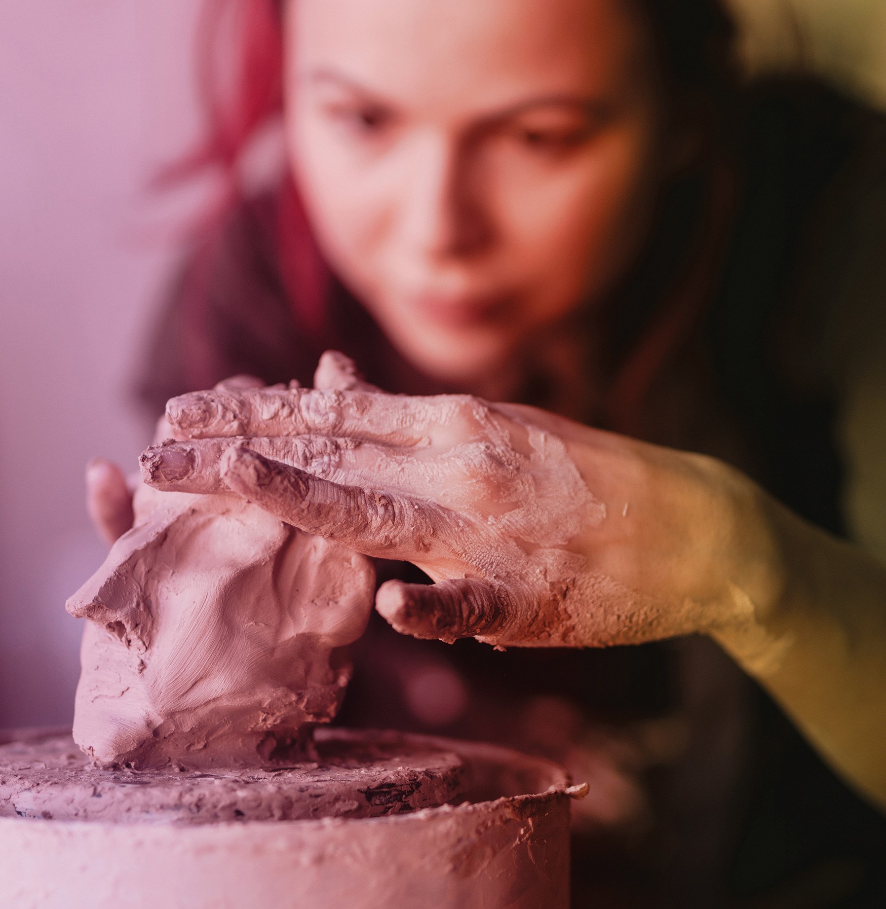 woman in art therapy session modeling her eyes fixed on her artwork