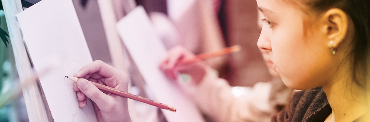 detail little girl drawing on an easel in plastic arts workshop